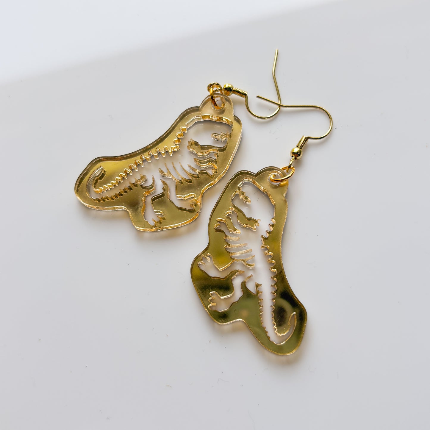 GOLD T-REX SKELETON ACRYLIC EARRINGS