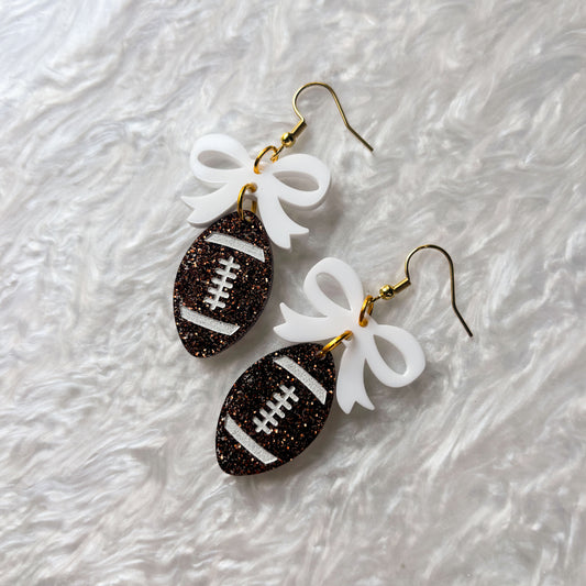 FOOTBALLS WITH BOWS ACRYLIC EARRINGS