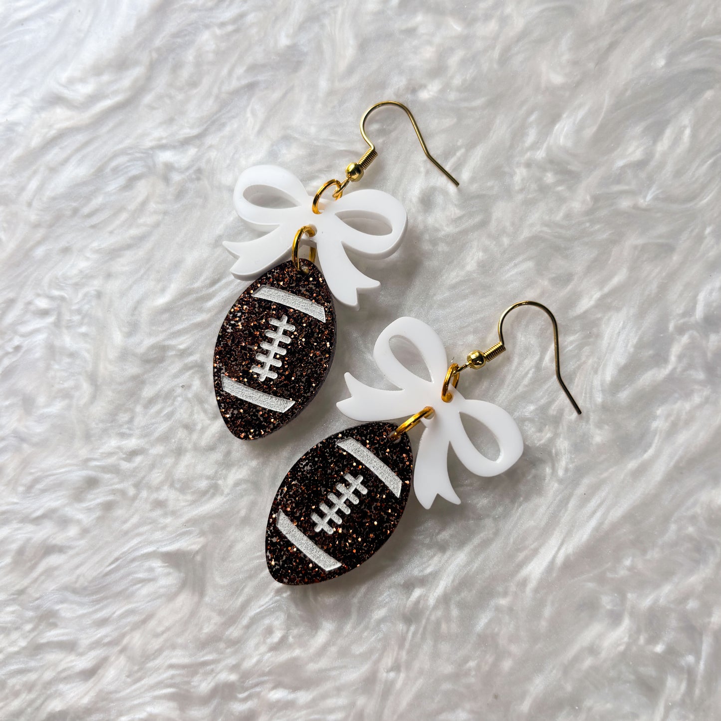 FOOTBALLS WITH BOWS ACRYLIC EARRINGS